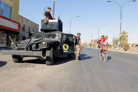 A cyclist gestures at Iraqi security forces, on a street of Kirkuk, Iraq October 19, 2017. REUTERS/Ako Rasheed - RC1433BB18F0