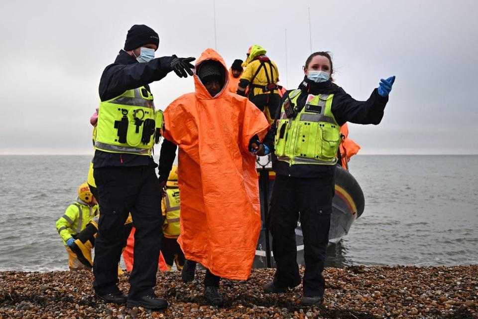 British Immigration Enforcement officers escort migrants, picked up at sea by an Royal National Lifeboat Institution (RNLI) lifeboat on December 09, 2022 (AFP via Getty Images)