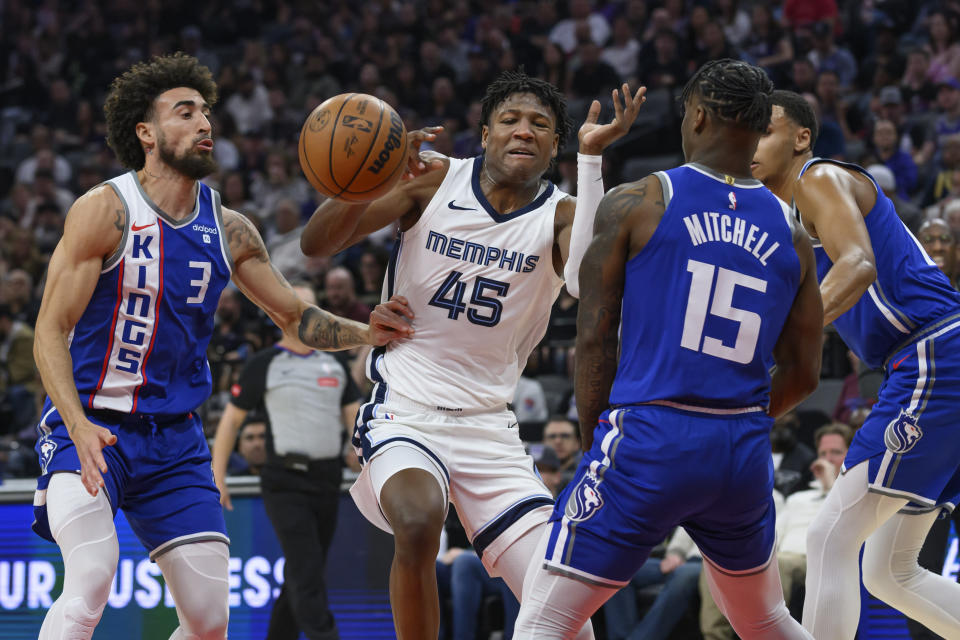 Memphis Grizzlies forward GG Jackson (45) is guarded by Sacramento Kings guard Chris Duarte (3) and guard Davion Mitchell (15) during the first half of an NBA basketball game in Sacramento, Calif., Monday, March 18, 2024. (AP Photo/Randall Benton)