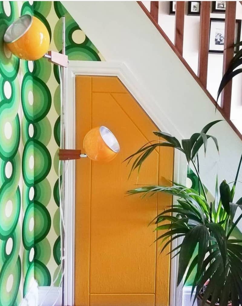 Green wallpaper with yellow under stair door