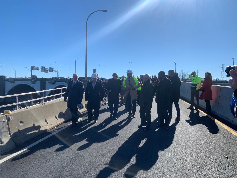 Federal highway officials, Gov. Dan McKee and other state officials gather at the Washington Bridge on Monday.