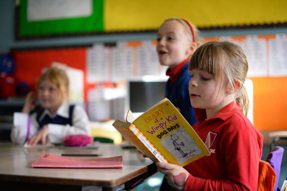Frances McMillan (right) reads a book inside a classroom at school on June 17, 2013.