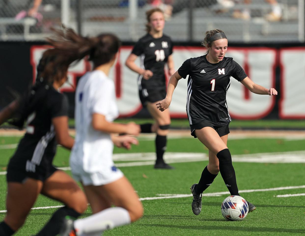 Manchester midfielder Katie Norris, right, takes the ball down the field during the second half of a Division III regional championship soccer game against Poland Seminary at Howland High School, Saturday, Nov. 5, 2022, in Howland, Ohio.