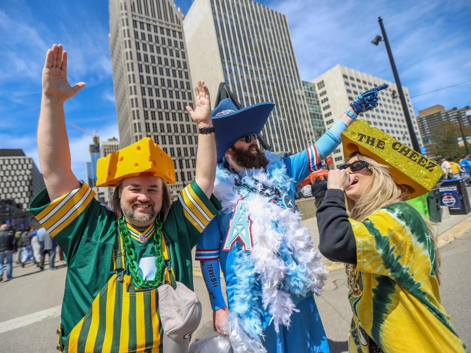 Barry Brown, 37, of Waco, Texas; Sam Dean 38, of Nashville, Tenn., and Brianne Braden, 34, of Milwaukee,  pose together for a a photo during the NFL Draft Experience in downtown Detroit on Friday, April 26, 2024.