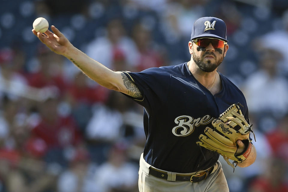 FILE - In this Aug. 18, 2019, file photo, Milwaukee Brewers third baseman Mike Moustakas throws the ball to first during a baseball game against the Washington Nationals in Washington. All-Star infielder Moustakas and the Cincinnati Reds have agreed to a $64 million, four-year contract, a person familiar with the negotiations told The Associated Press. The person spoke on condition of anonymity Monday, Dec. 2, 2019, because the agreement had not been announced. (AP Photo/Nick Wass, File)