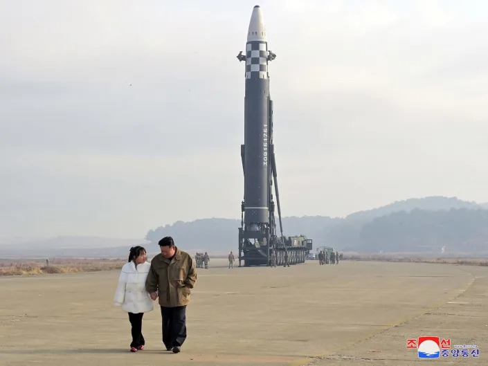 Kim Jong Un walking with a young girl that North Korea state news identified as his daughter.