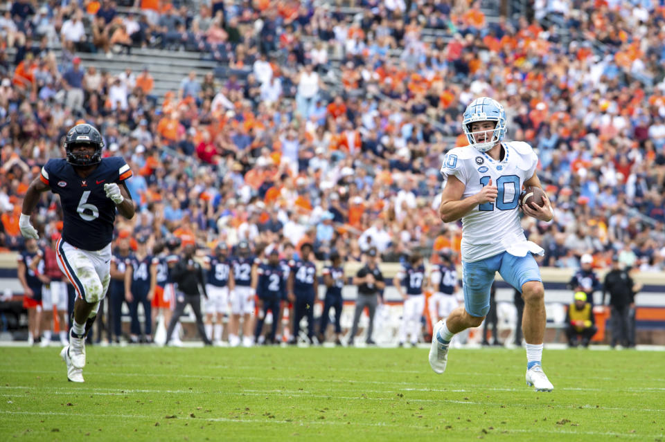 North Carolina quarterback Drake Maye (10) evades Virginia linebacker Nick Jackson (6) to score a touchdown during the first half of an NCAA college football game on Saturday, Nov. 5, 2022, in Charlottesville, Va. (AP Photo/Mike Caudill)