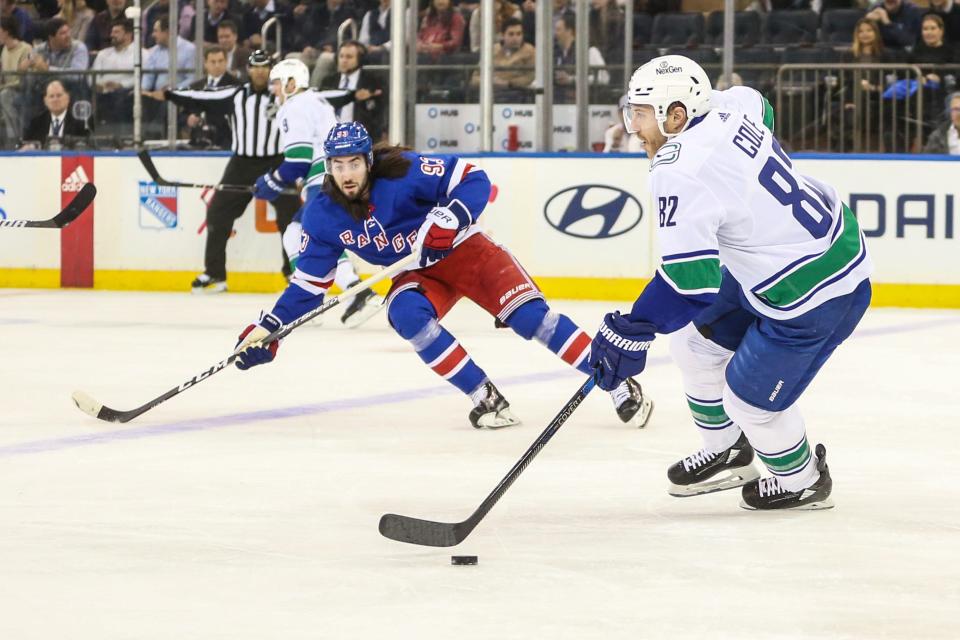 Jan 8, 2024; New York, New York, USA; Vancouver Canucks defenseman Ian Cole (82) attempts to skate past New York Rangers center Mika Zibanejad (93) in the first period at Madison Square Garden.