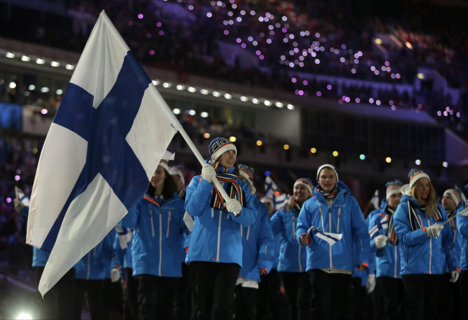 Enni Rukajarvi of Finland carries the national flag as she leads her team into the stadium during the opening ceremony of the 2014 Winter Olympics in Sochi, Russia, Friday, Feb. 7, 2014. (AP Photo/Matt Dunham)