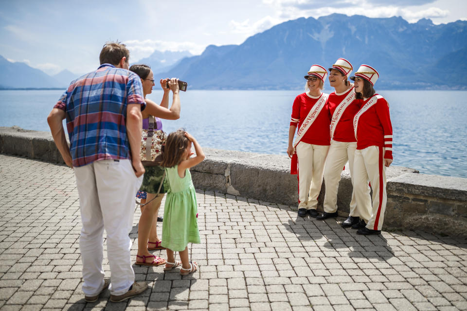 People in costumes pose for photos during the "Fete des Vignerons" (winegrowers' festival in French), parade during the official opening parade prior to the first representation and crowning ceremony in Vevey, Switzerland, Thursday, July 18, 2019. Organized in Vevey by the brotherhood of winegrowers since 1979, the event will celebrate winemaking from July 18 to August 11 this year. (Valentin Flauraud/Keystone via AP)