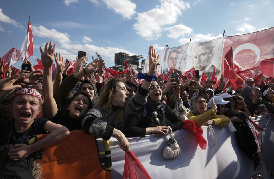 In this Saturday, March 23, 2019 photo, people chant slogans as they listen to Turkey's President Recep Tayyip Erdogan during a rally in Ankara, Turkey. As with previous elections, Erdogan has been holding multiple daily rallies across the country, using highly polarising language, portraying the opposition as traitors who are supported by terrorists, blaming ills on foreign forces and stirring up nationalist and religious sentiments.(AP Photo/Burhan Ozbilici)