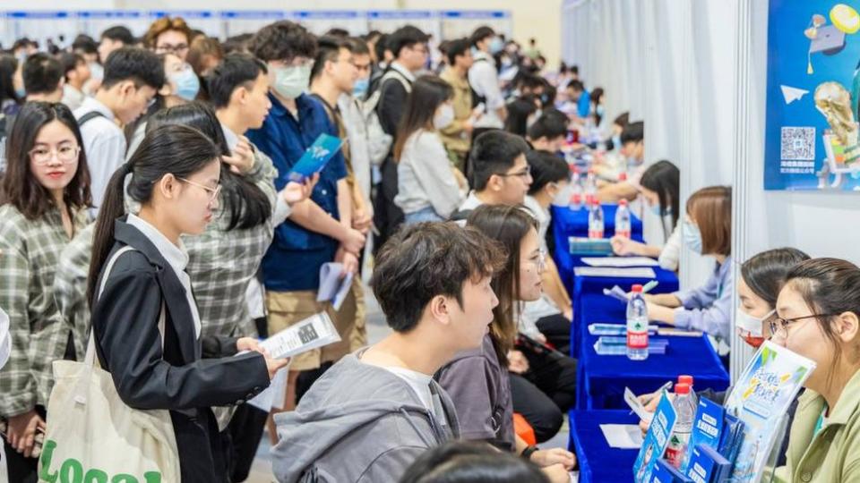 Jóvenes buscando empleo en una feria laboral en Pekín