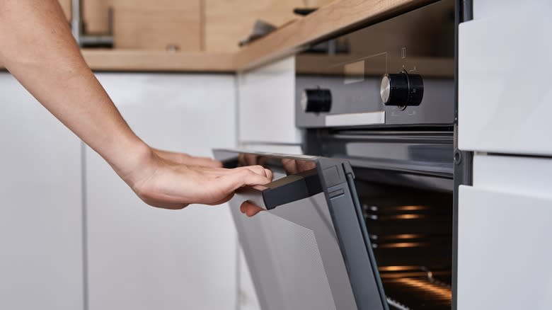 Opening oven door in kitchen