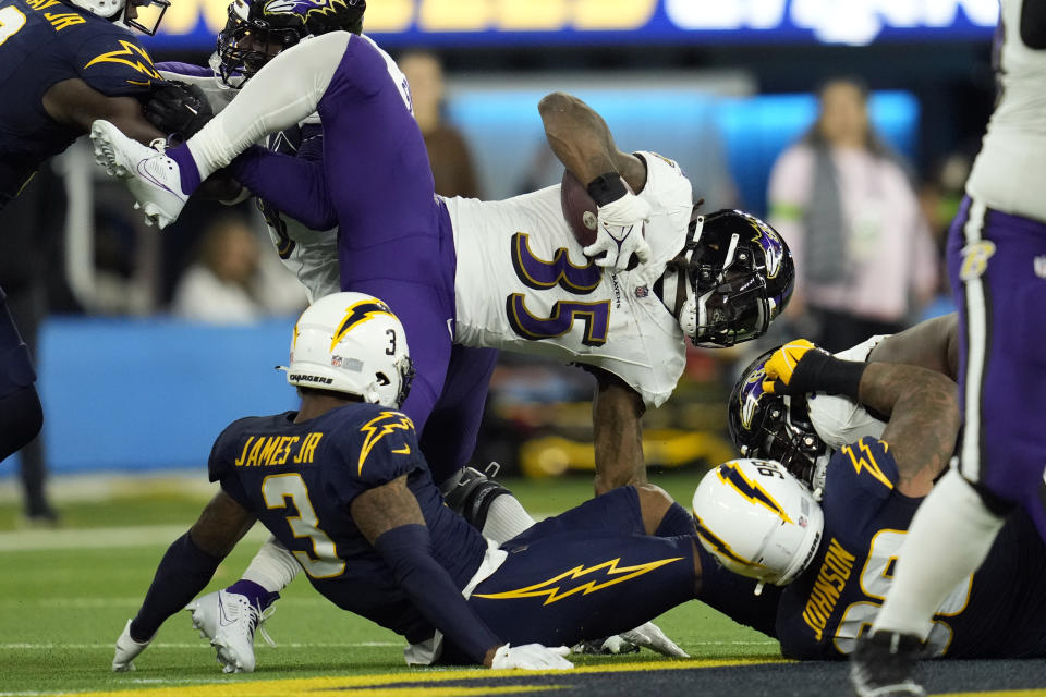 Baltimore Ravens running back Gus Edwards (35) leaps over Los Angeles Chargers safety Derwin James Jr. (3) during the second half of an NFL football game Sunday, Nov. 26, 2023, in Inglewood, Calif. (AP Photo/Ashley Landis)