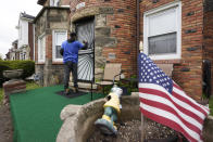 Sirgregory Allen leaves a flyer at a home in Detroit, Tuesday, May 4, 2021. Officials are walking door-to-door to encourage residents of the majority Black city to get vaccinated against COVID-19 as the city's immunization rate lags well behind the rest of Michigan and the United States. (AP Photo/Paul Sancya)