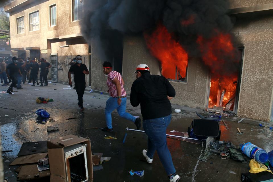 FILE - In this Oct. 17, 2020 file photo, the headquarters of Kurdish Democratic Party burn during a protest by pro-Iranian militiamen and their supporters in Baghdad, Iraq. Iran-aligned Shiite militias are posing an increasing challenge for Iraq ahead of key talks with Washington in early April 2021, that are meant to shape the future of the U.S.-Iraq relationship. (AP Photo/Khalid Mohammed, File)