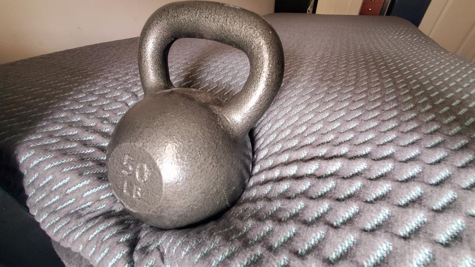 Kettlebell on the edge of the Tuft & Needle Mint Hybrid