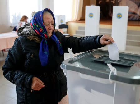 A woman casts a ballot during a presidential election at a polling station in Kozhushna, Moldova October 30, 2016. REUTERS/Gleb Garanich