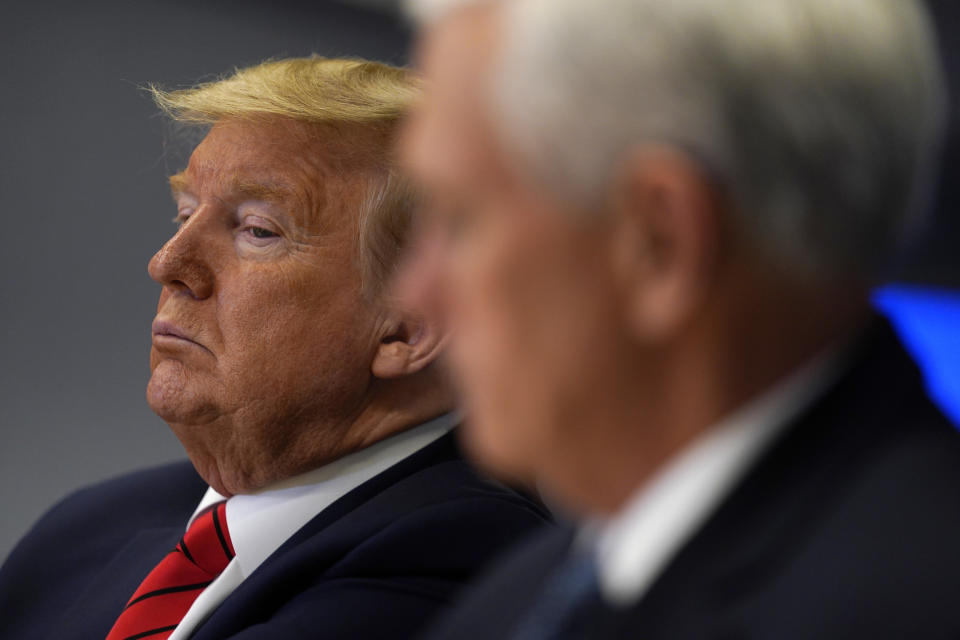 FILE - In this March 19, 2020, file photo President Donald Trump listens during a teleconference with governors at the Federal Emergency Management Agency headquarters in Washington. Vice President Mike Pence is at right. When President Donald Trump speaks, financial markets gyrate and quiver in real time. (AP Photo/Evan Vucci, Pool, File)