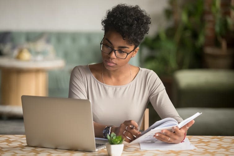 Woman taking notes from laptop