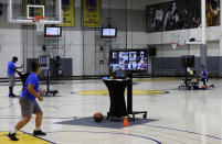 In this photo taken on Tuesday, June 9, 2020, coaches including VeAnne Navarro, left, work with virtual students at Golden State Warriors basketball camp in Oakland, Calif. The Warriors had to adapt their popular youth basketball camps and make them virtual given the COVID-19 pandemic. (AP Photo/Ben Margot)