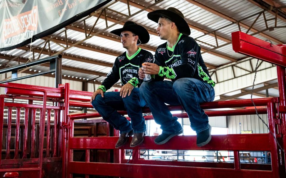 Austin Gamblers bull riders Jose Vitor Leme, left, and Adriano Salgado rest on a chute during practice last month. Leme is a two-time PBR world champion.