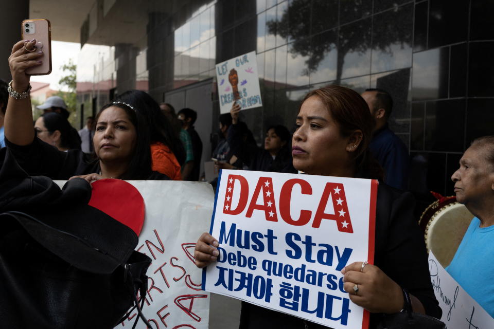 Beatrice Cruz of Arizona holds a sign in support of the Deferred Action for Childhood Arrivals (DACA) policy after a hearing on the DACA program in Houston in June