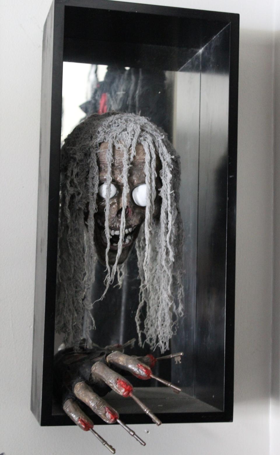 Inspired by a horror movie, artist Kody Clark created this wall art hanging in his Monroe home. Clark used mesh draping to create the hair, ping pong balls for the eyes and skeleton keys for the finger nails. "Art doesn't have to be bloody and gory to be scary," Clark said.