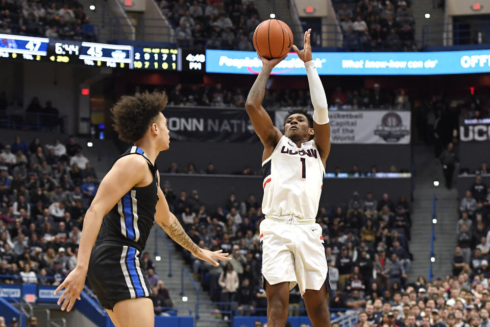 Connecticut's Christian Vital, right, shoots over Memphis' Lester Quinones during the second half of an NCAA college basketball game Sunday, Feb. 16, 2020, in Hartford, Conn. (AP Photo/Jessica Hill)