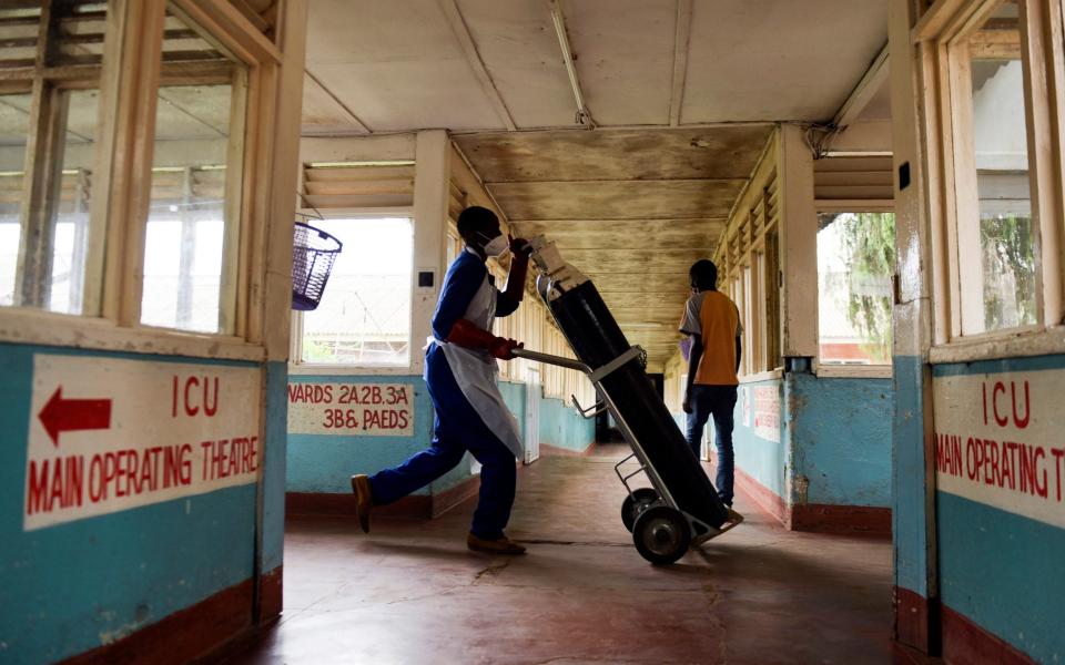 A health worker takes oxygen cylinders to Covid-19 wards at a hospital in Blantyre during a surge of cases triggered by the variant first found in South Africa - AP Photo/Thoko Chikondi