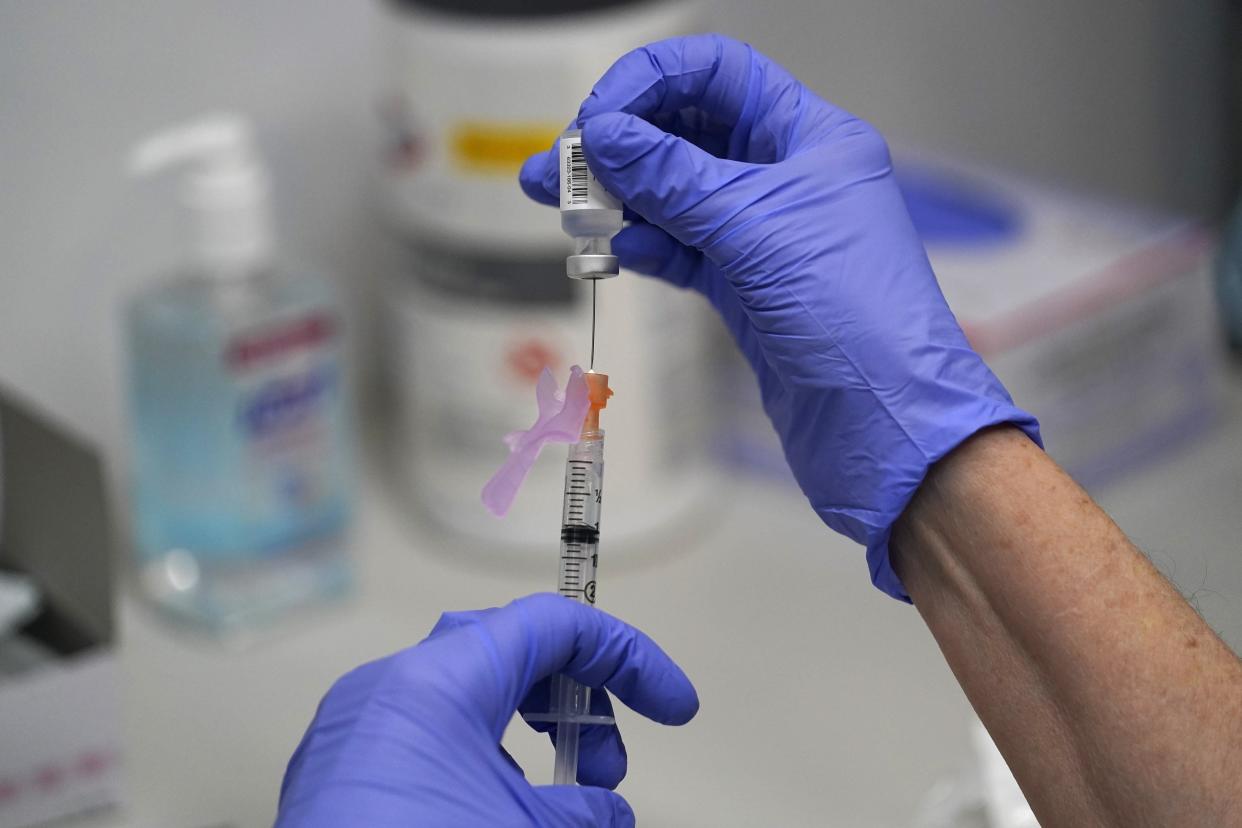 A pharmacy technician loads a syringe with the Pfizer-BioNTech COVID-19 Vaccine in 2021 at a mass vaccination site at the Portland Expo in Maine.