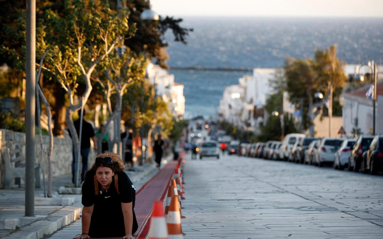 A pilgrim crawls from the port to the Holy Church of Panagia of Tinos, on the Aegean island of Tinos, Greece - AP