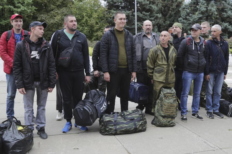 FILE - Russian recruits stand outside a military recruitment center in Volzhskiy, Volgograd region, Russia, Sept. 28, 2022. Since Russian President Vladimir Putin announced his mobilization on Sept. 21 for the war in Ukraine, independent media, human rights activists and draftees themselves have painted a bleak picture of a haphazard, chaotic and ethnically biased effort to round up as many men as possible and push them quickly to the front, regardless of skill or training. (AP Photo/File)