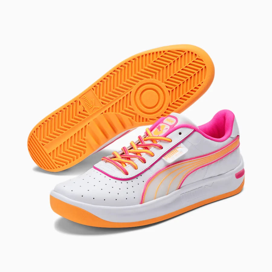 White sneakers with orange sole and pink interior with pink and orange shoelaces.