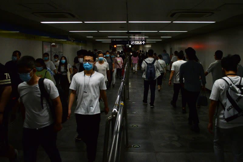 People wearing face masks walk inside a subway station, following the an outbreak of the novel coronavirus disease (COVID-19), in Beijing