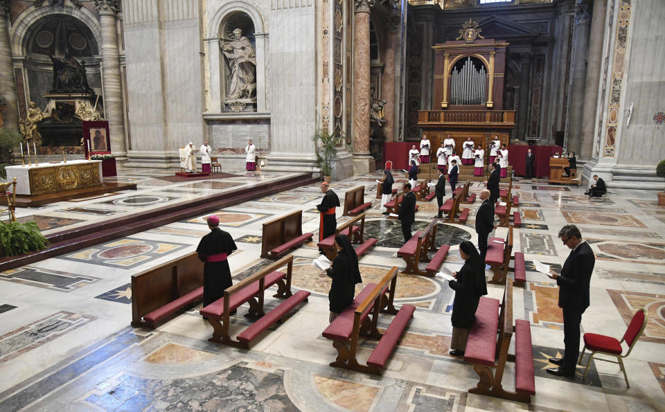 Pope Francis, small white figure at top left, leads a Mass for Holy Thursday, inside St. Peter's Basilica at the Vatican, Thursday, April 9, 2020. Francis celebrated the Holy Week Mass in St. Peter's Basilica, which was largely empty of faithful because of restrictions aimed at containing the spread of COVID-19. The new coronavirus causes mild or moderate symptoms for most people, but for some, especially older adults and people with existing health problems, it can cause more severe illness or death. (Alessandro Di Meo/Pool Photo via AP)