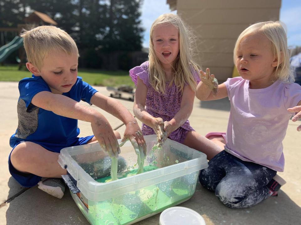 Kids do a simple science experiment outside. Camp counselors say getting outdoors is critical for kids' well-being.