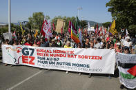 Anti-G-7 activists carry a banner during a protest on a road in Hendaye, France, Saturday, Aug. 24, 2019. World leaders and protesters are converging on the southern French resort town of Biarritz for the G-7 summit. President Donald Trump will join host French President Emmanuel Macron and the leaders of Britain, Germany, Japan, Canada and Italy for the annual summit in the nearby resort town of Biarritz. Banner in Basque, French and Spanish reads, "No to G7, Creating another world". (AP Photo/Bob Edme)