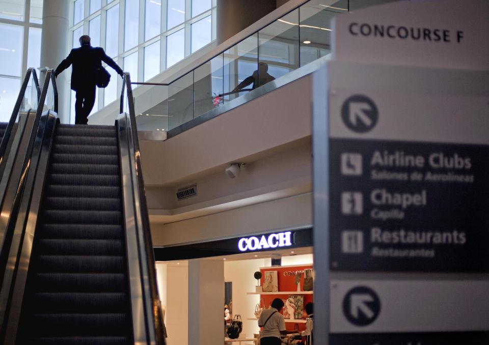 A passenger rides up an escalator past a boutique store at the new Maynard Holbrook Jackson Jr. International Terminal at Atlanta's airport on the first day it begins operating flights Wednesday, May 16, 2012, in Atlanta. (AP Photo/David Goldman)