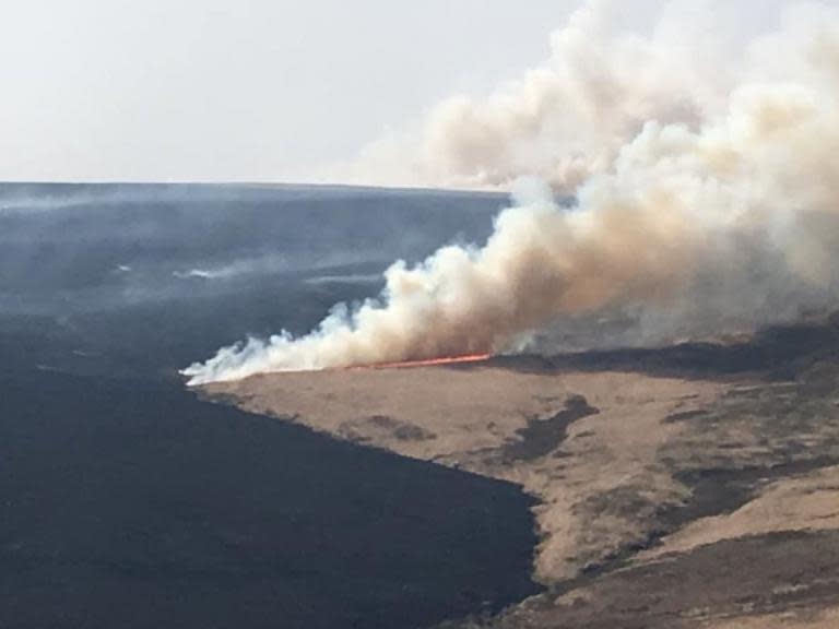 Firefighters have been tackling two massive moorland fires in record-breaking Easter temperatures, including one believed to have been sparked by a barbecue that has caused thousands of pounds' worth of damage.The National Trust said it had been forced to spend £2,000 an hour on a specialist firefighting helicopter to douse the flames at Marsden Moor, West Yorkshire.Restoration work on the moor has been wrecked, and it is feared that numerous animals including curlews, a kind of wading bird, have been killed.More than 50 firefighters, with at least 15 fire engines, battled to bring the flames under control in intense heat on one of the hottest days of the year.The Marsden fire began on Sunday, while other crews were still tackling an earlier wild fire, at Ilkley Moor, 35 miles away.And as Scotland recorded its warmest Easter Monday on record along with the rest of the UK, teams were called to a wildfire stretching for six miles across Moray.The three emergencies came after a week of protests in London over climate change, with thousands of Extinction Rebellion demonstrators calling for urgent action to prevent disastrous global temperature rises.The Marsden fire, near Huddersfield, which trust officials said was likely to have been caused by a barbecue, spread to Saddleworth, Greater Manchester, covering more than 300 hectares.Smoke could be seen for miles around as trust rangers beat down flames with specialist equipment.A spokesman said: “At present it is estimated that an investment of more than £200,000 in restoring this special habitat has been lost.“We’re devastated to see the destruction.“The deployment of the helicopter itself costs the National Trust, a conservation charity, £2,000 per hour.”Several blazes have already erupted this year on the moor, which is a Site of Special Scientific Interest, a Special Protection Area and Special Area of Conservation, thanks to its ground-nesting bird population and blanket bog habitat.A fire there in February damaged more than 100 hectares.Trust officials will meet fire chiefs this week to discuss the outbreaks.Local residents delivered food and water to crews during their long shifts.On Ilkley Moor, firefighters were damping down the flames that spread over 50 acres.Authorities advised people to keep windows and doors shut as a precaution and asked them to stay away from the moors.Three men – aged 19, 23 and 24 – were arrested over the Ilkley blaze. One has been charged with arson and two others have been released under investigation, West Yorkshire Police said.Scottish Fire and Rescue Service said nine fire appliances, a command support unit and two water carriers were battling flames near a wind farm on Moray.All four of the UK nations had their warmest Easter Monday on record, the Met Office said.There was a high of 25C at Heathrow and Northolt, in London, as well as Wisley, in Surrey.