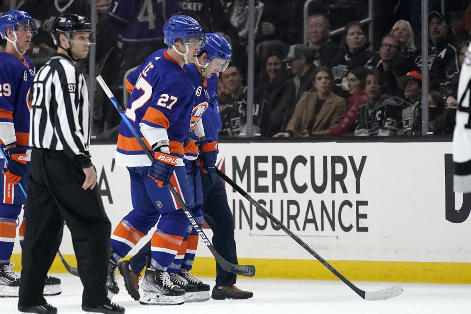New York Islanders center Mathew Barzal, right, is helped off the ice by left wing Anders Lee after being injured during the second period of an NHL hockey game against the Los Angeles Kings Saturday, Feb. 26, 2022, in Los Angeles. (AP Photo/Mark J. Terrill)