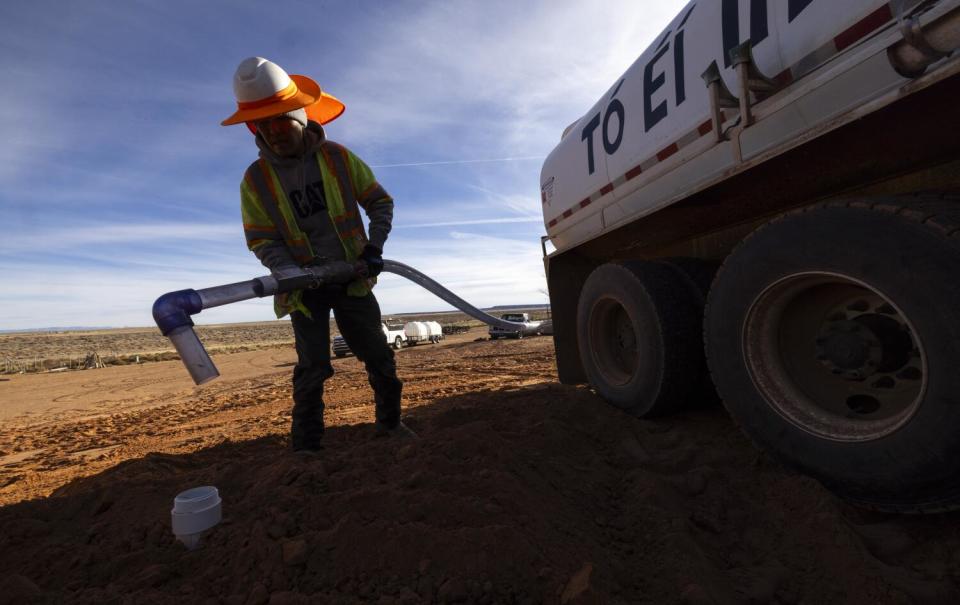 DigDeep employee Arvin Holiday fills a new cistern from a water tanker.