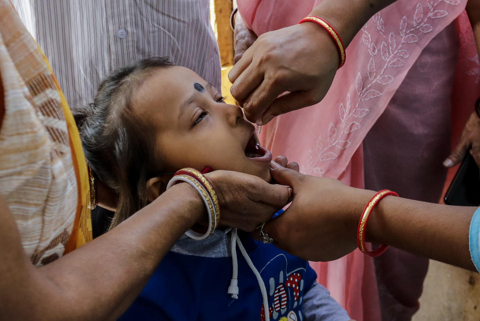 A child is administered polio vaccine at a booth in Kolkata, India, Sunday, Nov. 22, 2020. India's total number of coronavirus cases since the pandemic began has crossed 9 million. (AP Photo/Bikas Das)