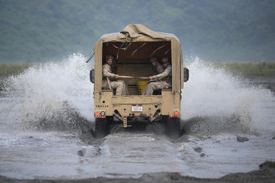 American Marines ride their vehicle across a stream during annual combat drills between the Philippine Marine Corps and U.S. Marine Corps in Capas, Tarlac province, northern Philippines, Thursday, Oct. 13, 2022. Truck-mounted launchers blasted off rockets Thursday and U.S. stealth fighter jets streaked across the northern Philippine sky in a combat drill and latest display of American firepower in a region where Washington has tried to deter what it warns as China's growing aggression. (AP Photo/Aaron Favila)