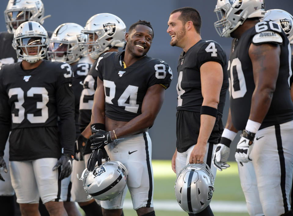 Aug 22, 2019; Winnipeg, Manitoba, CAN; Oakland Raiders wide receiver Antonio Brown (84) and quarterback Derek Carr (4) hold their helmets before a game against the Green Bay Packers at Investors Group Field. Mandatory Credit: Kirby Lee-USA TODAY Sports