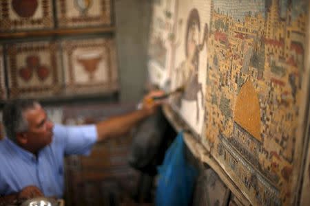 Archeology Nafez Abed cleans sculptures at his workroom, at Shati refugee camp in Gaza City, November 8, 2015. REUTERS/Suhaib Salem