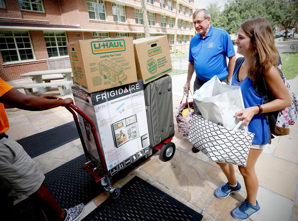 University President Kent Fuchs helps a freshman move her belongings into Broward Hall in 2016. Fuchs helped students move into their dorm rooms, ate at the dining hall and stayed in Jennings Hall with his wife for a week.