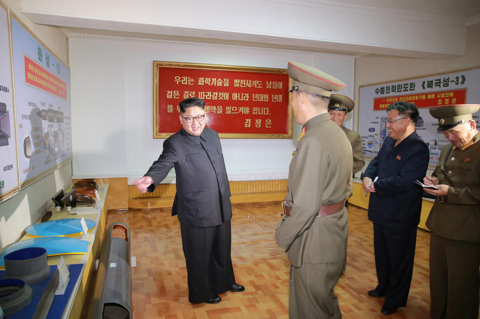 <em>Kim Jong-un was pictured at a factory inspection with wall charts of the weapons in the background (Reuters)</em>