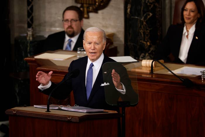 President Biden speaking at a podium with officials seated behind him