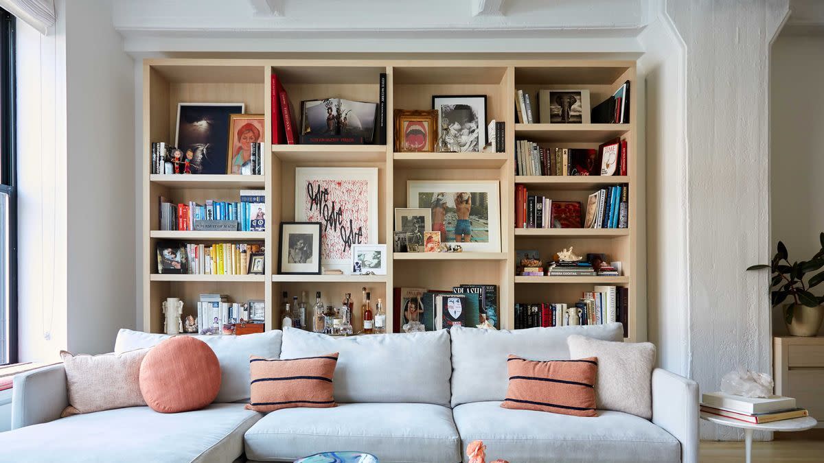 a living room with a white couch and a book shelf